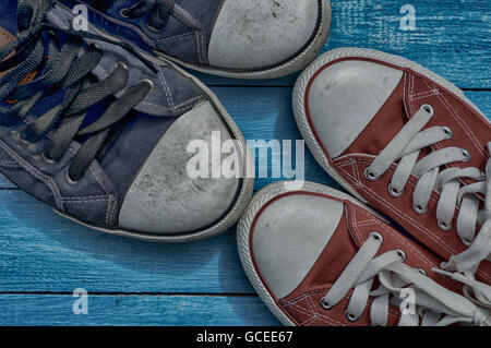 two pair of old worn sneakers on a blue shabby floor Stock Photo