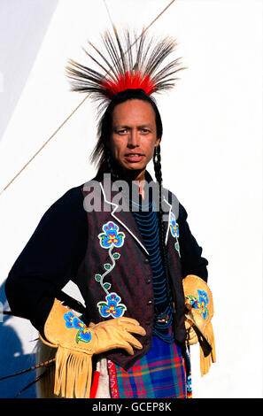 Native American man wearing ceremonial dress in front of Teepee, USA Stock Photo
