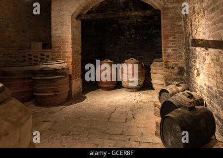 Wine cellar, old wine barrels and olive barrels, Abbazia di Monte Oliveto Maggiore, Tuscany, Italy Stock Photo