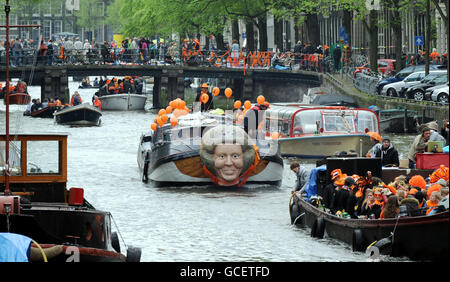 One of the Worlds biggest street parties takes place today as Holland celebrates Queensday. The canals and streets of Amsterdam are packed as tens of thousands celebrate the public holiday with models of Queen Beatrix of the Netherlands fixed to boats carrying party goers along the miles of canals. Stock Photo