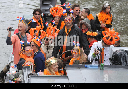 One of the Worlds biggest street parties takes place today as Holland celebrates Queensday. The canals and streets of Amsterdam are packed as tens of thousands celebrate the public holiday with models of Queen Beatrix of the Netherlands fixed to boats carrying party goers along the miles of canals. Stock Photo