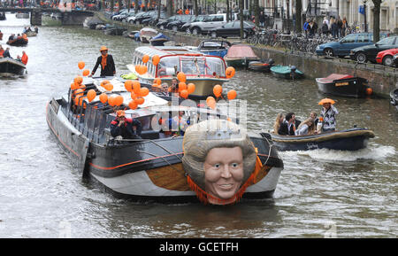 One of the Worlds biggest street parties takes place today as Holland celebrates Queensday. The canals and streets of Amsterdam are packed as tens of thousands celebrate the public holiday with models of Queen Beatrix of the Netherlands fixed to boats carrying party goers along the miles of canals. Stock Photo