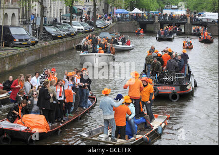 One of the Worlds biggest street parties takes place today as Holland celebrates Queensday. The canals and streets of Amsterdam are packed as tens of thousands celebrate the public holiday with models of Queen Beatrix of the Netherlands fixed to boats carrying party goers along the miles of canals. Stock Photo