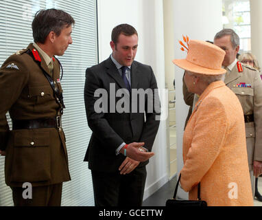 Britain's Queen Elizabeth II meets George Cross holder Chris Finney (centre) as she officially open one of the UK's top military buildings, in Northwood, West London. Stock Photo