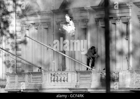 BBC sound recordist Sim Harris, one of the British hostages, scramble to safety as flames billow from the window at the Iranian Embassy in London when two explosions ended the six day siege at the building in Princes Gate. Fourteen hostages were brought out alive and a number of gunmen were detained. Stock Photo