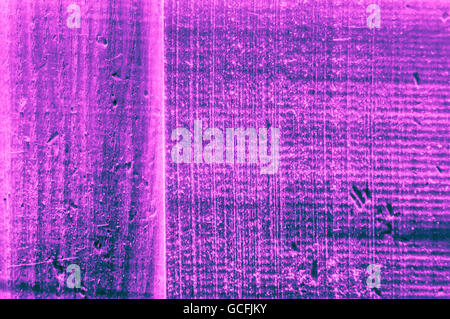 Rough grainy wood mainly pink blue purplish turquoise bluish violet colors hard light closeup Stock Photo