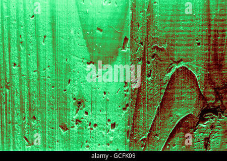 Rough grainy wood mainly light dark green reddish greenish colors hard light closeup Stock Photo