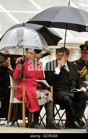 The Duchess of Cornwall and Defence Secretary Bob Ainsworth shelter from the rain at the Cenotaph in central London where they attended the national service of commemoration to mark the 65th anniversary of VE Day. Stock Photo