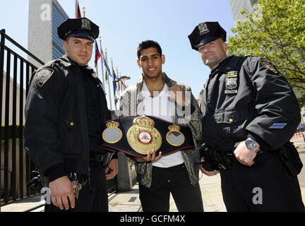 Great Britain's Amir Khan (centre) poses with Police officers in front of the United Nations Headquarters during the media call in New York City, USA. Stock Photo