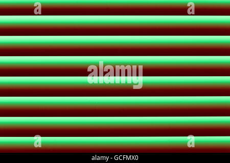 Fine light dark green reddish greenish jalousie venetian blind with mat daylight falling through variant Stock Photo