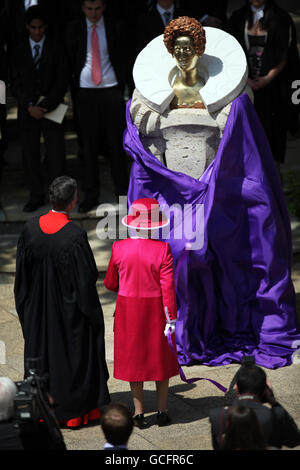 Britain's Queen Elizabeth II unveils a new statue of Queen Elizabeth I at Westminster School as part of a visit to the school and Westminster Abbey, on the 450th anniversary of the granting of their Royal Charter by Queen Elizabeth I. Stock Photo