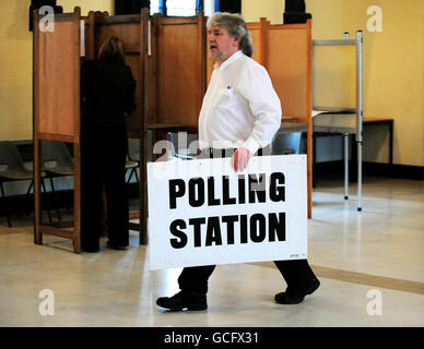 A member of staff carries a sign across the polling station at Market Hall, Swadlincote, Derbyshire, as voting in the General Election got underway across the UK. Stock Photo