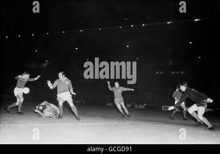 Benfica's Fernando Cruz (l) and Germano (3rd left) thwart Real Madrid's Alfredo Di Stefano (on floor) during an attack watched by Real Madrid's Ferenc Puskas (4th left) and Benfica goalkeeper Alberto da Costa Pereira (r). The game finished 5-3 to Benfica. Stock Photo