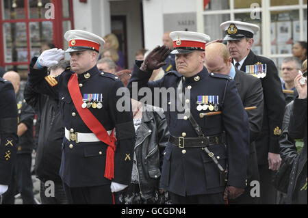 Royal Marines salute as the hearse carrying coffin of the British serviceman Corporal Christopher Harrison of 40 Commando, Royal Marines, passes through the High Street of Wootton Bassett, Wiltshire. Stock Photo