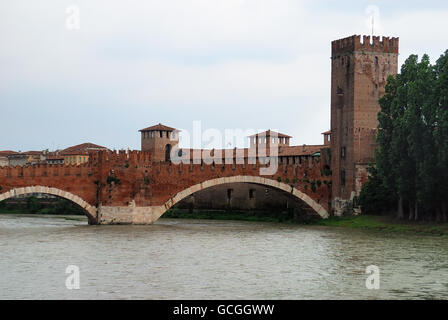 Verona, Italy. The Castelvecchio Bridge (Italian: Ponte di Castelvecchio) or Scaliger Bridge (Italian: Ponte Scaligero) is a fortified bridge over the Adige River. It was built (most likely in 1354-1356) by Cangrande II della Scala, to grant him a safe way of escape from the annexed eponymous castle in the event of a rebellion of the population against his tyrannic rule. The bridge was however totally destroyed by the retreating German troops on April 24, 1945. A faithful reconstruction begun in 1949 and was finished in 1951, with the exception of the left tower. Stock Photo