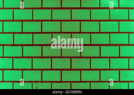 dirty and grainy light dark green reddish greenish vintage city tiles underground style wall with some splashes like color dots Stock Photo