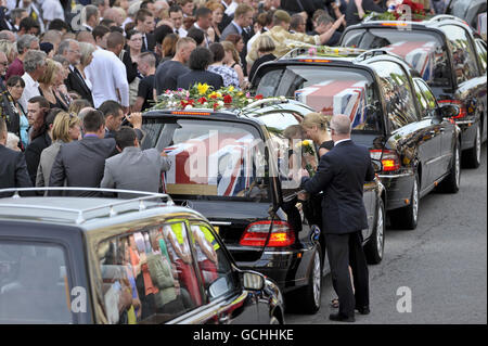 Mourners watch as the funeral cortege makes it's way through Wootton Bassett high street, during the repatriation of seven British servicemen, who were killed in Afghanistan. Stock Photo