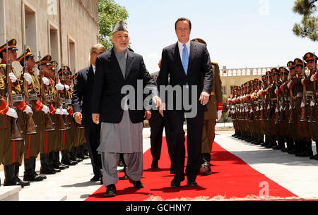 Britain's Prime Minister David Cameron walks with President Hamid Karzai, at the Presidential Palace in Kabul, on his first visit to Afghanistan since taking office. Stock Photo