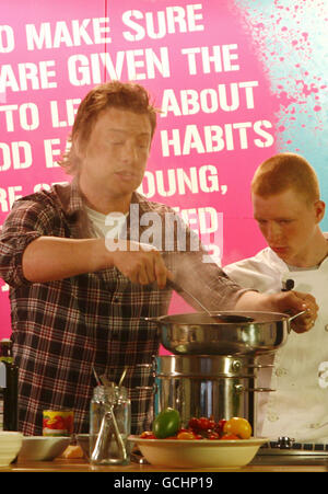 Jamie Oliver launches a new cooking skills qualification for secondary schools at the Hospital Club in central London, with 15-year-old budding chef Chris Statham (right) from Regent's College in London, one of the colleges that will be involved in the scheme. Stock Photo