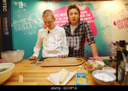 Jamie Oliver launches a new cooking skills qualification for secondary schools at the Hospital Club in central London, with 15-year-old budding chef Chris Statham (left) from Regent's College in London, one of the colleges that will be involved in the scheme. Stock Photo