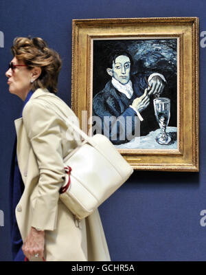 A visitor walks past Pablo Picasso's Portrait of Angel Fernandez de Soto, which is estimated to fetch 30-40 million and is being offered by the Andrew Lloyd Webber Foundation, at Christie's in London, part of their Masterpieces Through The Ages exhibition which is open to the public until Thursday and features some of the highlights of the summer auction season. Stock Photo