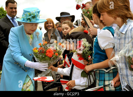 Queen Elizabeth II is given flowers by children after unveiling a statue of Oscar Peterson the legendary Canadian jazz pianist, after unveiling it in Ottawa city centre, Canada. Stock Photo