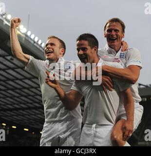 Jamie Redknapp (centre) celebrates with team mates Olly Murs (left) and Teddy Sheringham (right) after scoring the opening goal for England during the 2010 Socceraid match at Old Trafford. Stock Photo