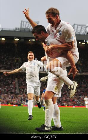 Jamie Redknapp (centre) celebrates with team mates Olly Murs (left) and Teddy Sheringham (right) after scoring the opening goal for England during the 2010 Socceraid match at Old Trafford. Stock Photo
