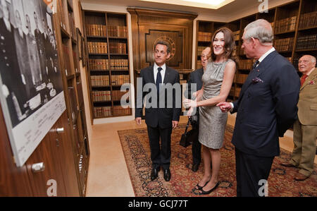 French President Nicolas Sarkozy (left), his wife Carla Bruni-Sarkozy (centre) and Britain's Prince Charles, look at photographs of French President Charles De Gaulle during a visit to the former headquarters of the Free French, at Carlton Gardens in central London. Stock Photo