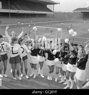 The Hilton Honeys (white sweaters) and The Playboy Bunnies cheer on their men colleagues at Arsenal's Highbury stadium where the London Hilton Hotel was meeting The Playboy Club in the final of the Hotel and Restaurant Junior Charity Cup Stock Photo