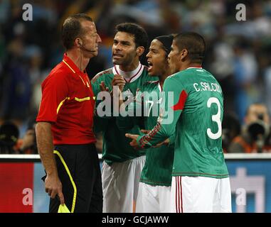 (left-right) Mexico's Rafael Marquez, Dos Santos Giovani and Carlos Salcido appeal to the linesman after they concede the opening goal of the game Stock Photo