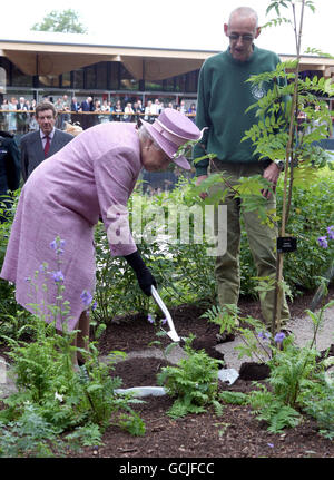 Britain's Queen Elizabeth II plants a tree as she officially opens a visitor centre at the Royal Botanic Gardens in Edinburgh. Stock Photo