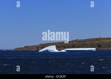 Two icebergs near Cape Spear, Newfoundland and Labrador, Canada with the lighthouse, buildings and viewpoint in the background. Stock Photo