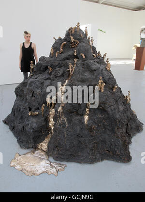 Royal College of Art worker Sonya Barber views Rose Gibbs' 'Mountain', Bronze 2010 as the RCA Painting and Sculpture students unveiled their latest contemporary artworks at the Royal College of Art Sculpture School. Stock Photo