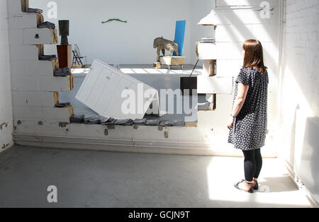 A member of the public looks at Pablo Wendel's untitled sculpture (the hole in the wall) as the RCA Painting and Sculpture students unveiled their latest contemporary artworks at the Royal College of Art Sculpture School. Stock Photo