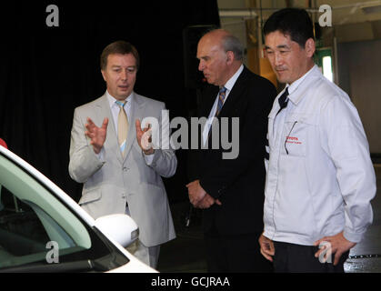 of Toyota executives Didier Leroy, President of Toyota Motor Europe (left) and Katsunori Kojima, Toyota UK Director (right) with Business Secretary Vince Cable at the launch of the Toyota Auris Hybrid car at the Toyota plant, Burnaston, near Derby. Stock Photo