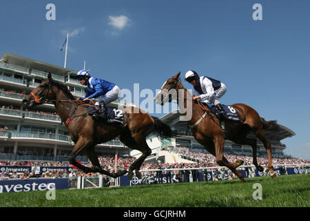 Horse Racing - Investec Derby Festival - Ladies Day - Epsom Racecourse. Rumoush ridden by Richard Hills (left) and Gertrude Bell ridden by William Buick (right) during Ladies Day at Epsom Downs Racecourse, Surrey. Stock Photo