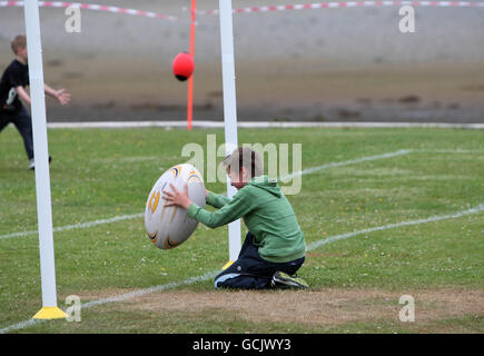 Children take part during Street Rugby on The Green in Lochgoilhead, Scotland. Stock Photo