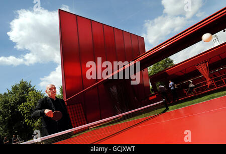 French architect Jean Nouvel plays table tennis as he inspects his design for the Serpentine Gallery Pavilion in Kensington Gardens, London. Stock Photo