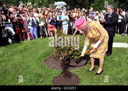 Britain's Queen Elizabeth II plants a tree in the garden of Government House, during a visit to Winnipeg, Canada. Stock Photo