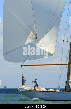 Sailing - British Classic Yacht Club Panerai Cowes Regatta - Day Three - The Solent. The crew of Wings set the spinnaker on the third day of the British Classic Yacht Club Panerai Cowes Regatta on the Solent. Stock Photo