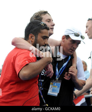 Great Britain's Alistair Brownlee is helped away following the running section of the Dextro Energy ITU World Championship Triathlon, in Hyde Park, London. Stock Photo