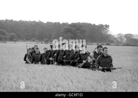 A file of armed police making their way back through a field near Malton, North Yorkshire, after searching a wood during the hunt for gunman Barry Prudom. Stock Photo