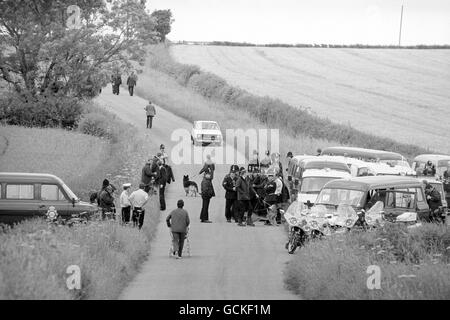 A mother wheels her child past police officers about to continue their search of the are around Malton, North Yorkshire, in the hunt for triple killer Barry Prudom. Stock Photo