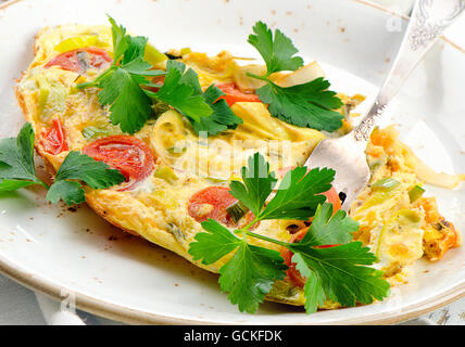 Omelet with vegetables in white plate. Selective focus Stock Photo
