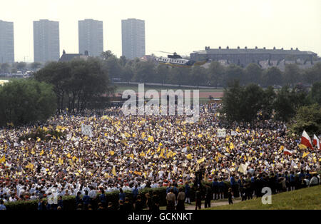 The huge crowd looks skyward as the helicopter carrying Pope John Paul II arrives at Bellahouston Park, Glasgow, on the fifth day of his historic visit to Britain. He celebrated Mass before an estimated one third of Scotland's Roman Catholics. Stock Photo