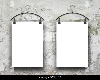 Close-up of two square blank frames hanged by clothes hanger against scratched concrete wall background Stock Photo