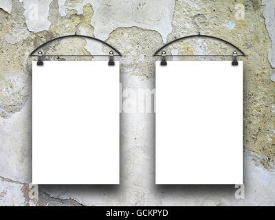 Close-up of two square blank frames hanged by clothes hanger against cracked wall background Stock Photo