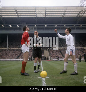 Referee Ken Aston, centre, looks on as captains Noel Cantwell of Manchester United, left, and Leicester City's Colin Appleton toss the coin before the start of the match Stock Photo