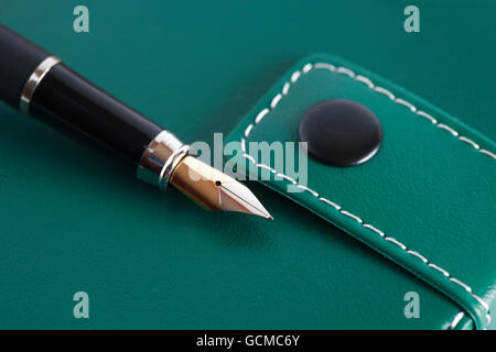 Closeup of fountain pen on green leather notebook Stock Photo